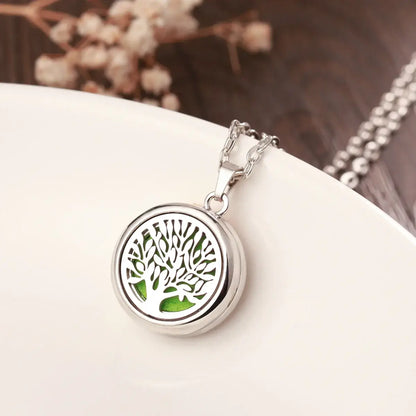 Elegante collar difusor de aromaterapia en acero inoxidable con diseño de árbol y espacio para aceites esenciales.
